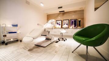 Experience a calm and professional atmosphere in this well-designed room, featuring a white examination chair, a unique green chair, and a medical cart.