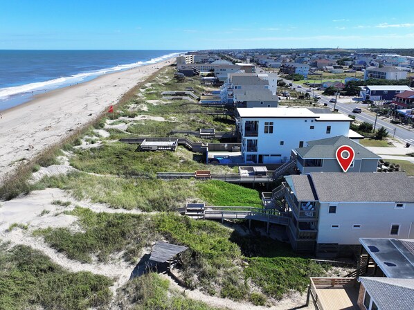 Zona residencial costera con casas, una playa y un muelle.