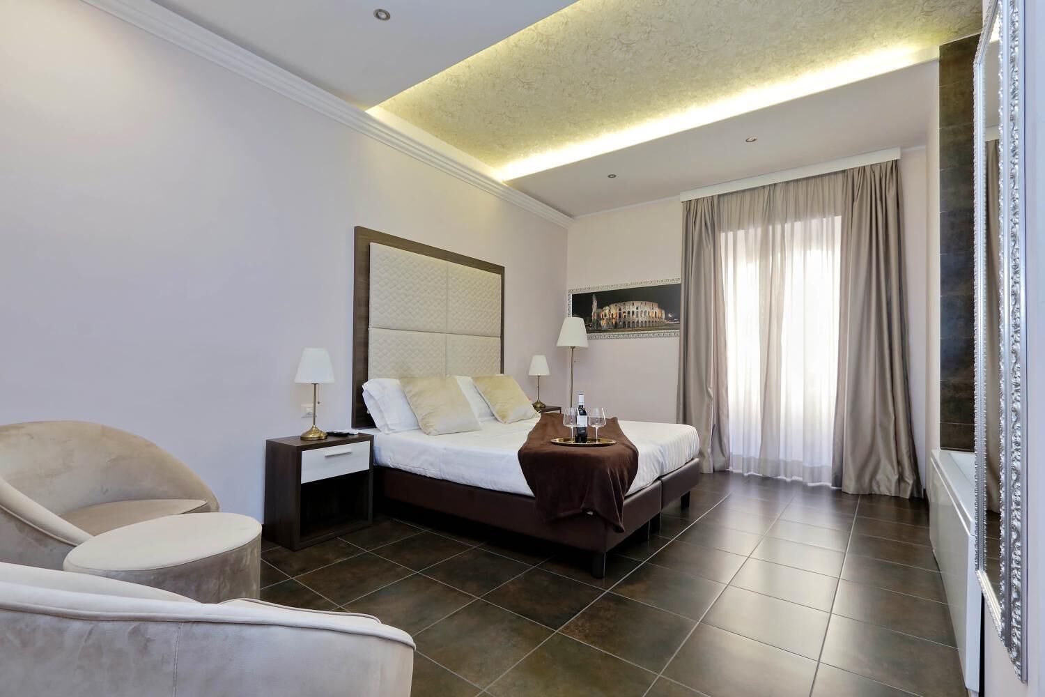 A hotel room with a bed, nightstands, a chair, a large mirror, and a painting on the wall.