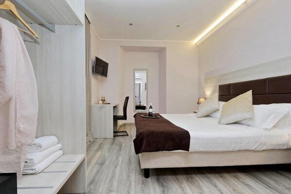 Une chambre d’hôtel moderne, équipée d’un lit, d’une table de chevet et d’un miroir.