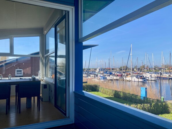 A room with a large window overlooking a marina with boats.