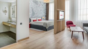Een moderne hotelkamer met een groot bed, een bureau, een stoel en een televisie.