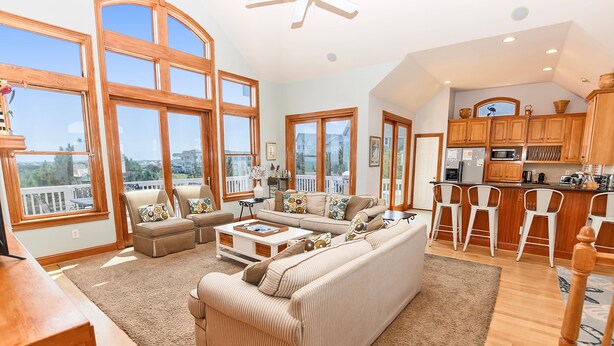 A spacious living room with a large sofa, a coffee table, and a view of the balcony. - Soundside, Private Pool, Rec Room, Hot Tub, CC204, Aqua Holic (Corolla)
