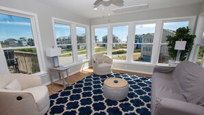 A spacious living room with large windows, a patterned rug, and modern furniture. - Semi-Oceanfront, Private Pool, Poolside Bar, Hot Tub, Ocean Views! T1, Sailaway (Kitty Hawk)