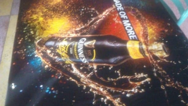 Een bar met een Guinness-reclame op de vloer.