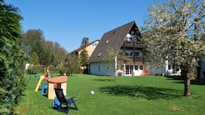 Ein Wohngebiet mit einem Haus, einem Spielplatz und einer Rasenfläche.