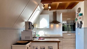 A modern kitchen with a central island, built-in appliances, and a skylight.