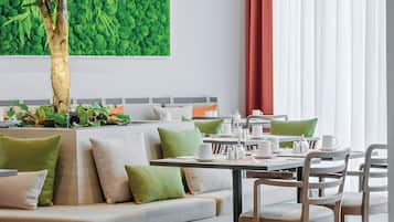 Ein moderner Essbereich mit einer Couch, Stühlen und einem für das Essen gedeckten Tisch.