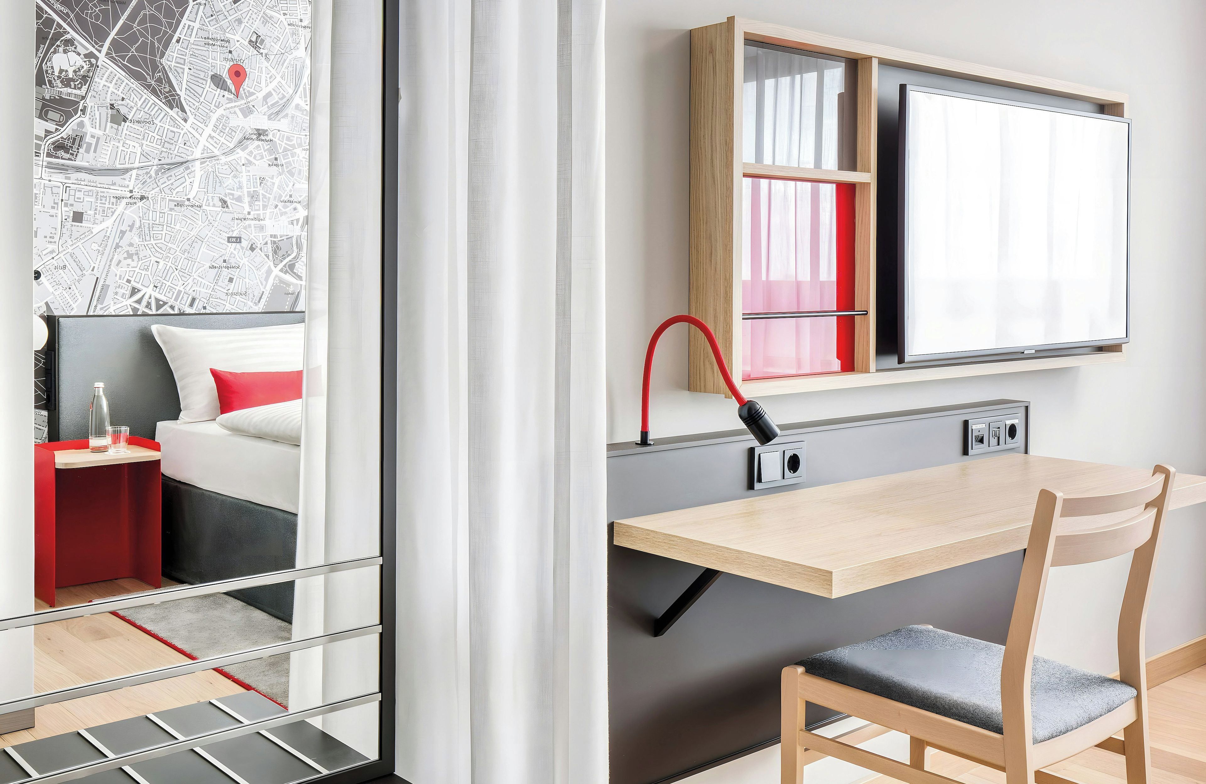 A modern room with a bed, a desk, and a chair.