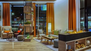 Una sala de estar moderna con chimenea, asientos y una estantería.