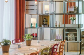 Un comedor con una mesa de madera, sillas y una planta en maceta.
