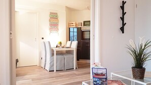 A modern kitchen with a dining area, a coat rack, and a potted plant. - Urlaub und Erholung mit Charme und Stil auf Rügen (Sellin)