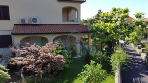 A residential property with a garden, a stone wall, and a tiled roof. - Apartment-studio Ginkgo A1 (Medulin)