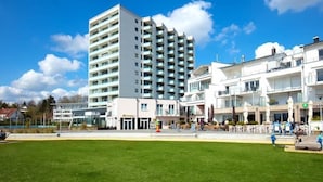 Et moderne hotel med flere etager, en central gårdhave og udendørs siddepladser.