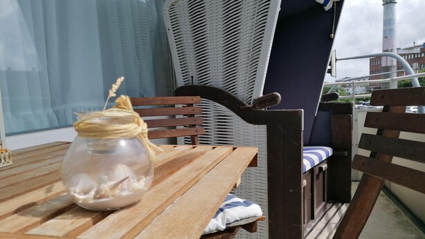 A wooden table with a glass jar and a blue and white striped cushion. - Sylter Strandgut, Haus Germania (Sylt)