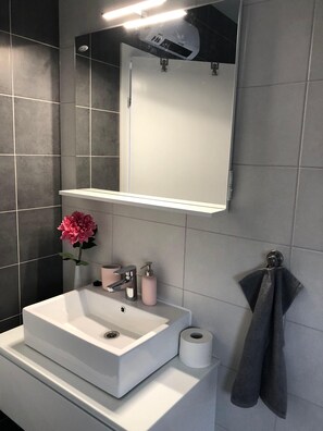 A bathroom with a white sink, mirror, and a towel rack. - Studioapartment "carpe Diem" (Kastela)
