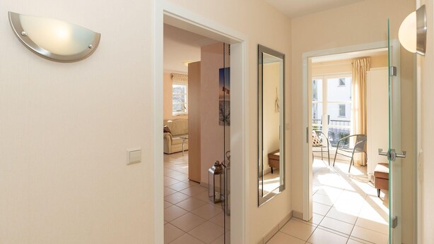 A hallway with a glass door leading to a balcony. - Villa Katharina, WE 5 / 9965 (Kuehlungsborn)