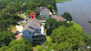 An aerial view of a residential area with houses surrounded by trees and a body of water. - Soundfront, Sound View, Hot Tub, Community Amenities, 528, Celestial Haven (Corolla)