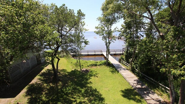 A lakeside pathway with a wooden deck leading to a dock. - Soundfront, Sound View, Hot Tub, Community Amenities, 528, Celestial Haven (Corolla)