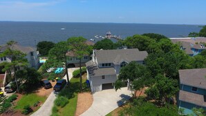 A residential area with houses, a swimming pool, and a dock extending into the water. - Soundfront, Sound View, Hot Tub, Community Amenities, 528, Celestial Haven (Corolla)