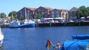 Un port avec des bateaux, un bâtiment doté de nombreuses fenêtres et un ciel dégagé.