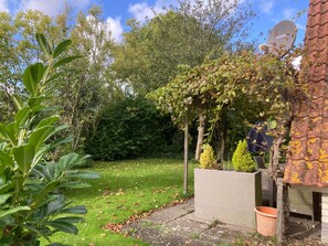 A garden with a pergola, a brick wall, and a satellite dish. - Holiday Home de Druif 6p With a Nice Terrace Near Lake Lauwersmeer (Anjum)