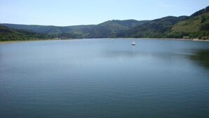 A calm lake surrounded by hills. - Ferienhaus Pahl in Wolfshagen (Langelsheim)