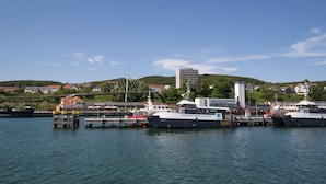 A marina with several boats docked, a bridge, and buildings in the background. - Fewo Hiddenseeblick (Dranske)