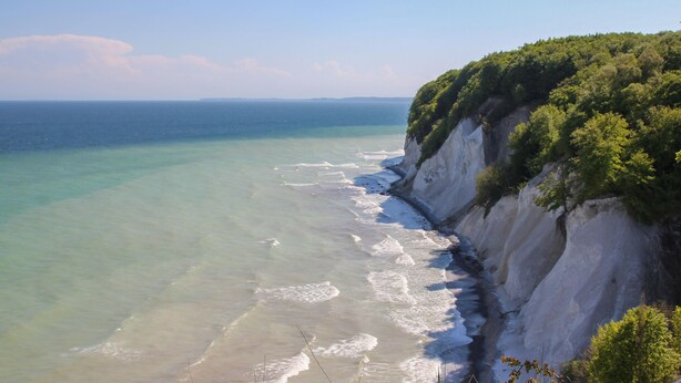 A coastal landscape with a clear view of the ocean and a cliff with vegetation. - Fewo Hiddenseeblick (Dranske)