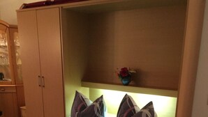 A bedroom with a bed, a wardrobe, and a small trash bin. - Apartment Pahl (Langelsheim)