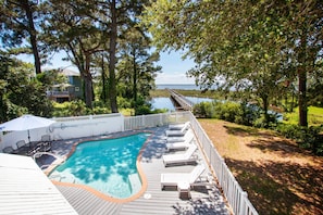 A wooden deck with a swimming pool, lounge chairs, and a view of a lake. - Soundfront, Sound views, Private Pool, Hot Tub, MS12, Sounds Amazing (Corolla)