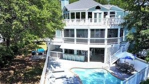 A multi-story house with a swimming pool, deck chairs, and a covered outdoor area. - Soundfront, Sound views, Private Pool, Hot Tub, MS12, Sounds Amazing (Corolla)