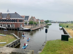 A canal with boats, a bridge, and buildings along the water.