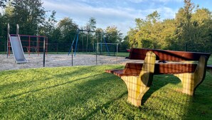 A park with a playground, a bench, and a grassy area. - Charming Holiday Home 40m2 Near the Lauwersmeer (Anjum)