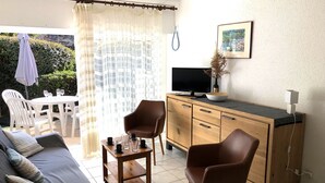A living room with a sofa, two chairs, a coffee table, a TV, and a cabinet. - PORT AN DRO - Studio in holiday rental in Carnac - UD98 (Carnac)