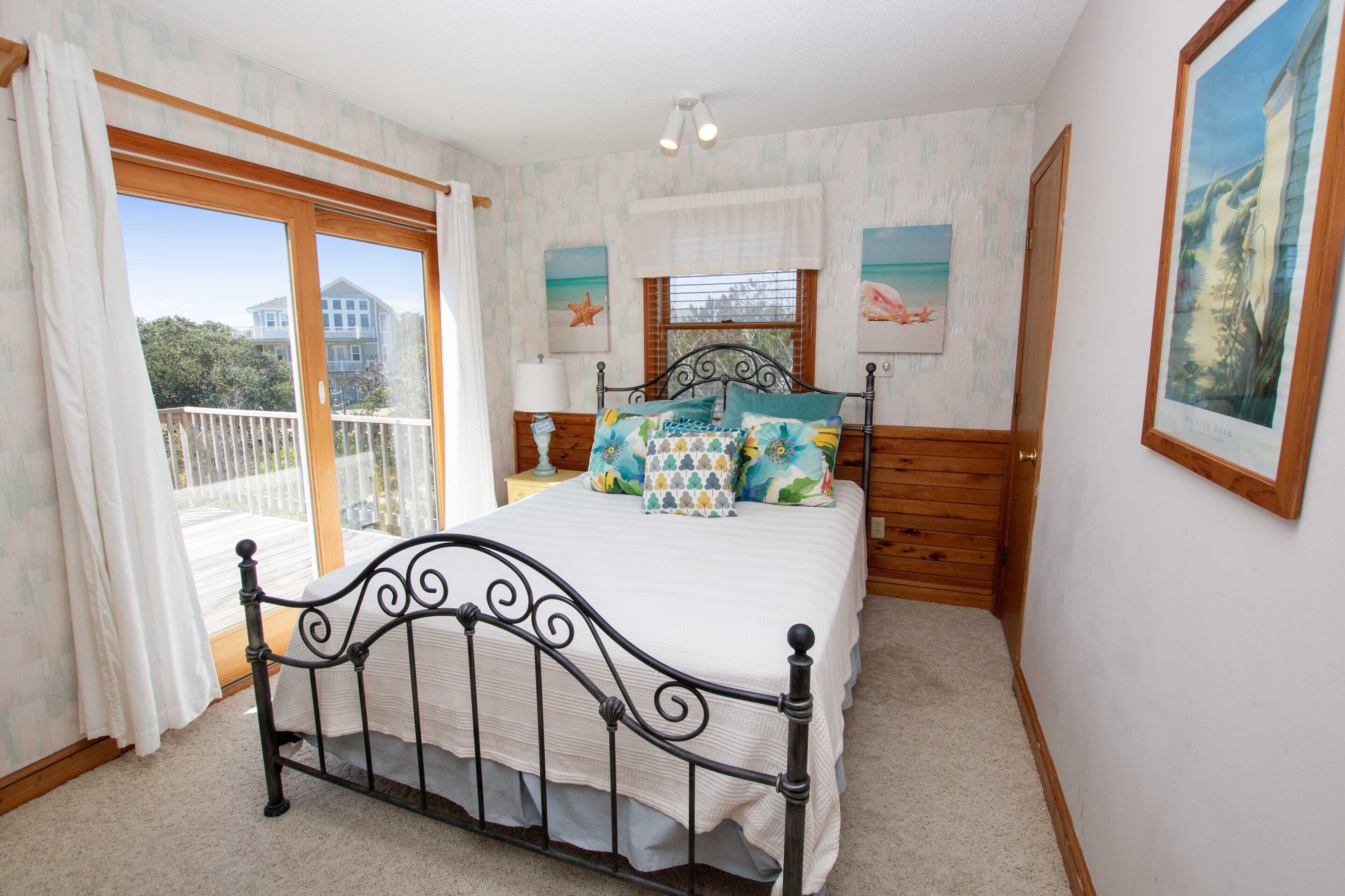 A bedroom with a bed, a window, and a balcony.