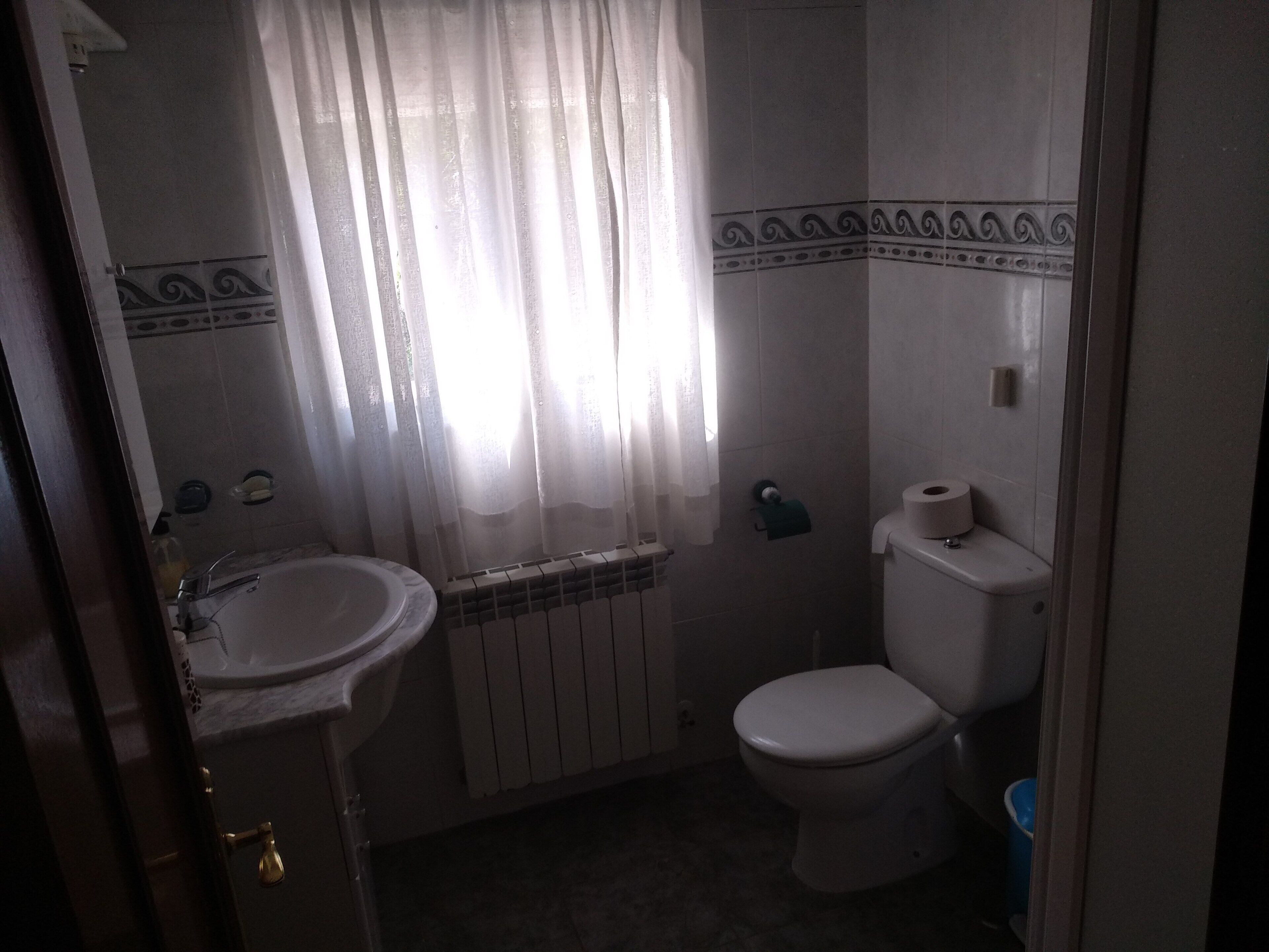 Une salle de bain comprenant des toilettes, un lavabo et un espace douche.