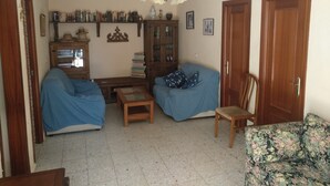 A living room with two blue sofas, a wooden cabinet, and a floral sofa. - Quinta La Alpujarra (Batres)