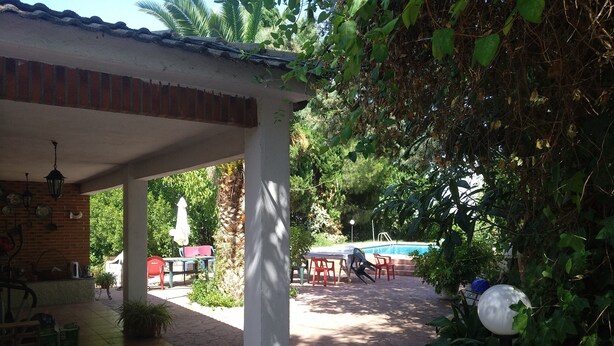 A covered patio area with a pool, outdoor seating, and a pergola. - Quinta La Alpujarra (Batres)