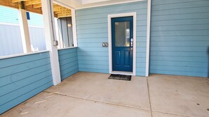 A corner of a house with a blue door, a concrete floor, and a wooden ceiling. - Moms Dream- Oceanside, Comm Pool, Hot Tub, Yard, CB10, Dads Mercedes (Corolla)