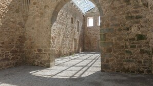 An arched stone corridor with a gravel floor and a skylight. - Neya Porto Hotel (Porto)