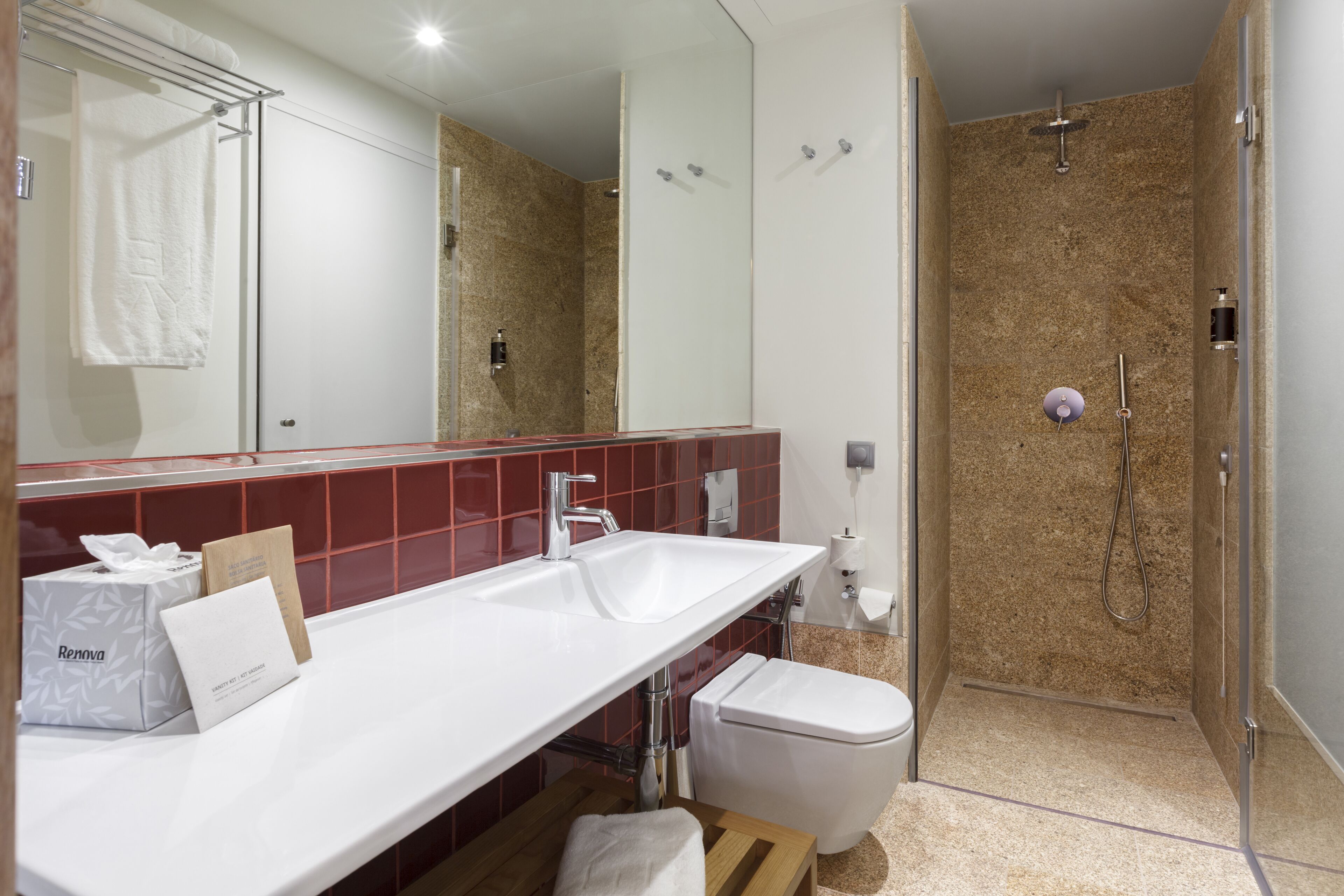 Une salle de bain moderne avec un meuble-lavabo blanc, une douche et des toilettes.