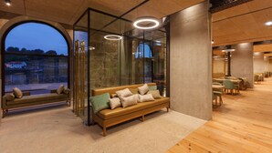 A modern interior with a wooden bench, glass walls, and a view of the outside. - Neya Porto Hotel (Porto)