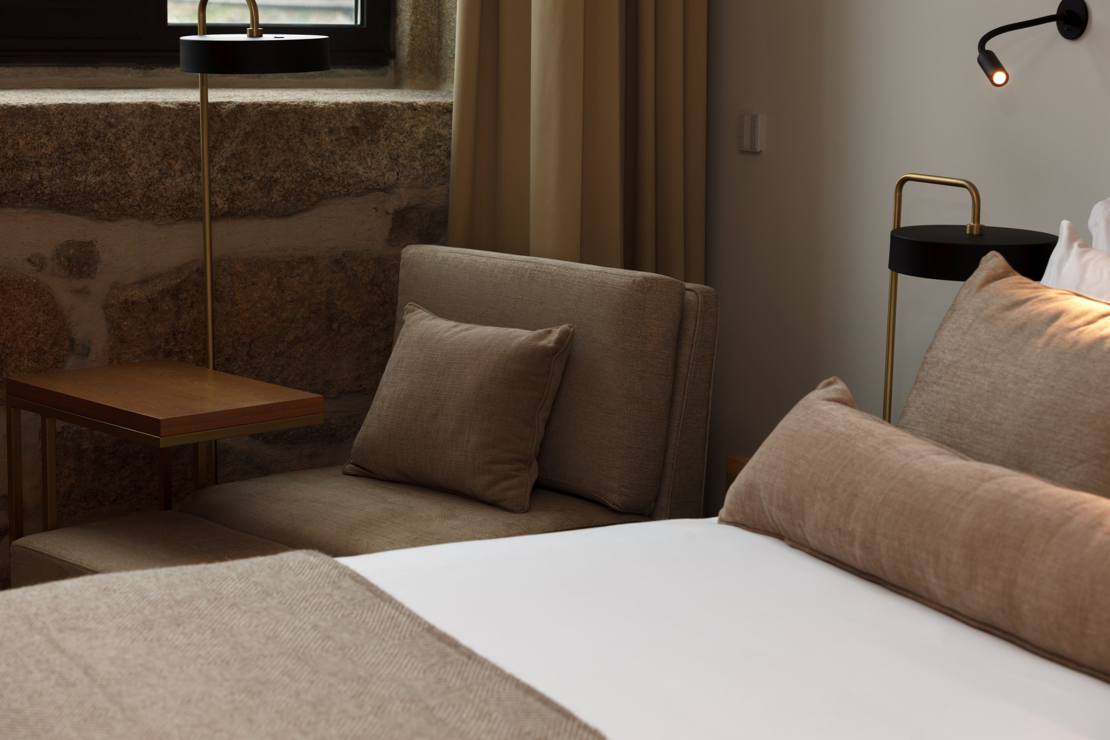 Une chambre à coucher moderne avec un lit, une table de chevet, une chaise et une lampe.