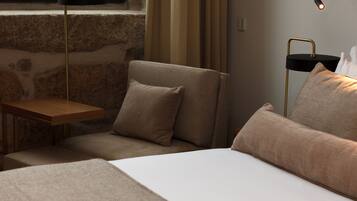 Une chambre à coucher moderne avec un lit, une table de chevet, une chaise et une lampe.