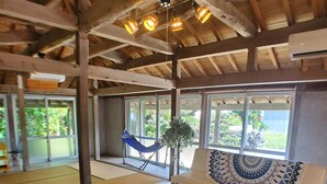 Een traditionele kamer met tatami matten, een bank, een houten tafel en een hangmat.