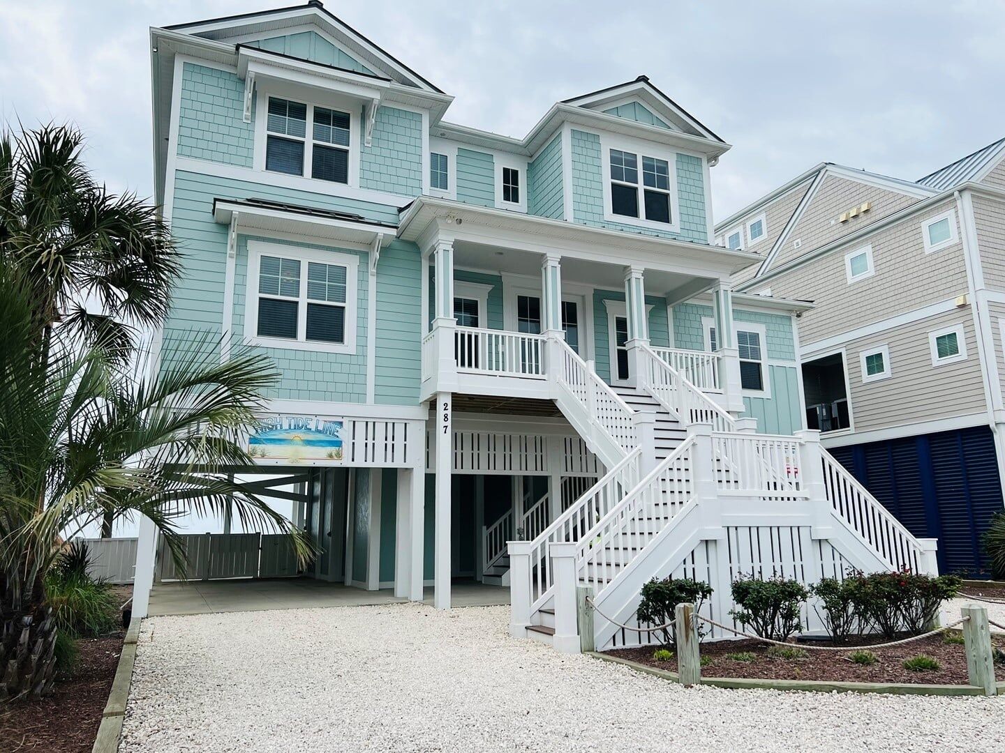 A two-story building with a balcony and a staircase leading to the entrance.