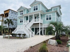A two-story house with a covered porch and a staircase leading to the upper floor.