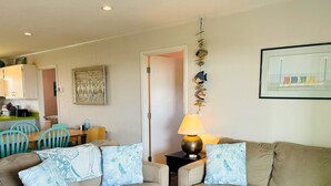 A living room with two sofas, a coffee table, a dining area with chairs, and a kitchen in the background. - Lime Inn 4 Bedroom Home by RedAwning (Supply)