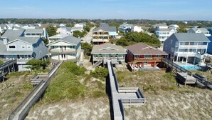 A coastal residential area with houses connected by a wooden boardwalk. - Lime Inn 4 Bedroom Home by RedAwning (Supply)